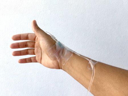Focus on the hand of a patient in hospital ward on white background.の写真素材