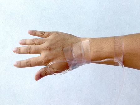 Focus on the hand of a patient in hospital ward on white background.の写真素材