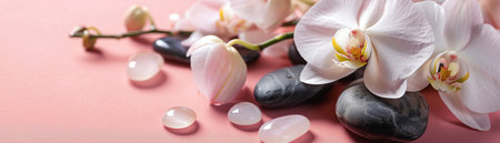 Spa scene with white orchids and polished stones against a pink background, evoking relaxation and tranquility.の素材