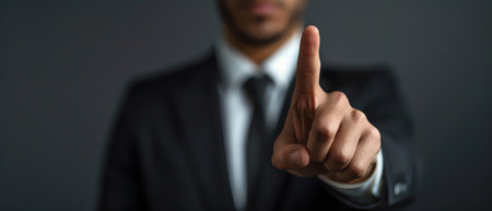 A charismatic and confident man in a suit gestures with one finger raised, as if presenting or introducing an important conceptの素材