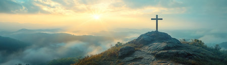 A cross atop a misty mountain, with sun rays piercing through clouds, creating a heavenly atmosphereの素材
