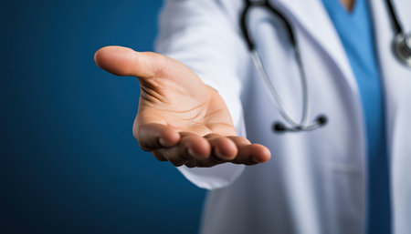 Female doctor extending her hand, inviting gesture, blue backdropの素材