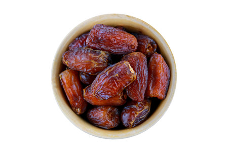 Dried dates in a bowl isolated on a white background. Top view.の写真素材