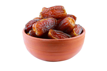 Dates fruit in a clay bowl isolated on a white background. Clipping Path Includedの写真素材