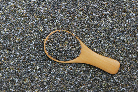 Chia seeds in wooden spoon on grey background, top view.の写真素材