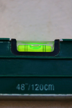 Green spirit level on a white background, closeup of photo.