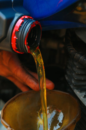 Oil pouring from the engine of a motorbike, close-upの写真素材