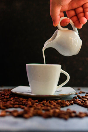 Pouring milk into a cup with coffee beans. Selective focus.の写真素材