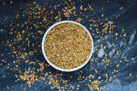 Dried Oregano in a bowl on a dark background. Top view.の写真素材