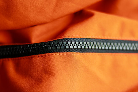 Zipper on the orange jacket. Close-up view of the zipper.の写真素材
