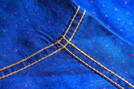 Close-up of blue jeans fabric with stitch, texture, background