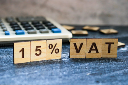 VAT - Value Added Tax acronym on wood block with calculator backgroundの写真素材