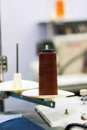 Sewing machine and thread on the table in the factory