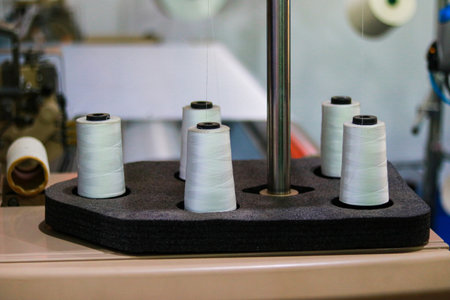 Spools of white thread on a sewing machine, close-up