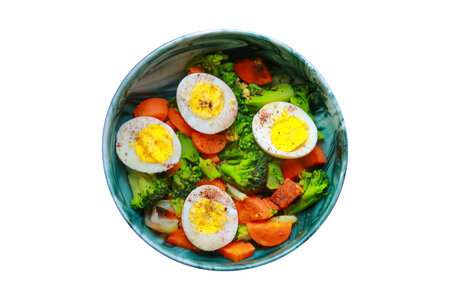Healthy boiled egg and broccoli salad with carrots isolated on whiteの写真素材