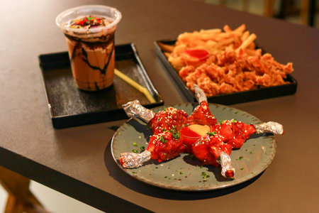 Spicy Red Chicken Lollipops with Sesame Seeds and Foil Wrapped Handlesの写真素材