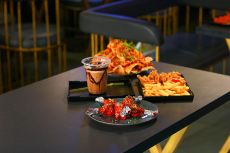 Variety of Fast Food Appetizers and Chocolate Milkshake on a Cafe Tableの写真素材