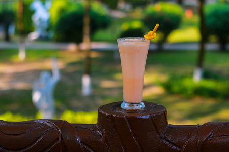 Tropical Papaya Smoothie or Melon Shake in a Tall Glass with Orange Strawの写真素材