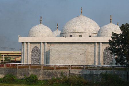 Beautiful Modern White Mosque with Minaret and Domes under Clear Blue Skyの写真素材