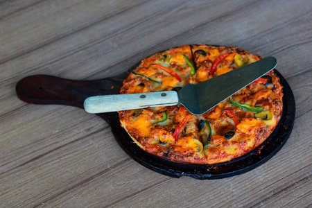 Homemade Pizza with Olives and Peppers Served on Wooden Pizza Paddleの写真素材
