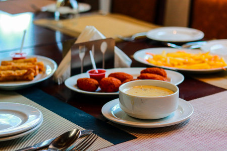 Assorted Appetizers Platter with Creamy Soup and Fried Snacks in Restaurantの写真素材