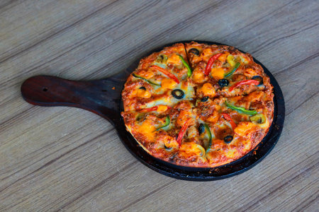 Homemade Pizza with Olives and Peppers Served on Wooden Pizza Paddleの写真素材