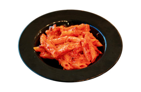 Penne Pasta in Creamy Tomato Sauce Served on a Black Plateの写真素材