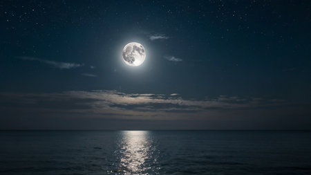 The night sky with a rare supermoon casting a silver light over a calm oceanの素材