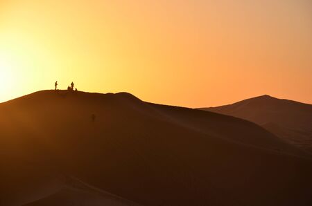 Moroccan dessert with tourist silhouettes on the backgroundの写真素材