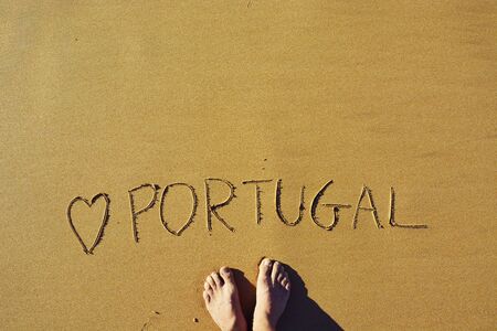 Man Standing on Top of a Carved Love Portugal on the Sandの写真素材