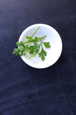 Top view parsley in bowl on black backgroundの写真素材