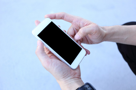 Smartphone in hand, hand holding smartphoneの写真素材