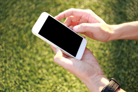 Hand holding smartphone with blank screenの写真素材