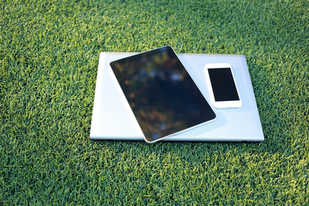 smartphone, tablet and laptop on artificial turf