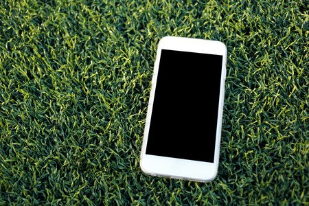 smartphone with blank screen on artificial turf