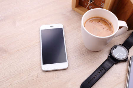smartphone and coffee cup on wooden backgroundの写真素材