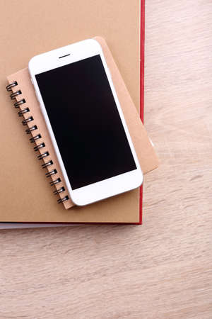 top view smartphone on book and glasses on wooden backgroundの写真素材