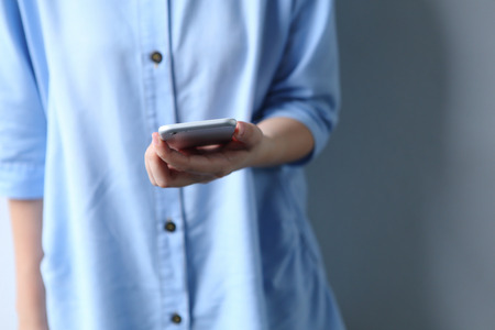 Woman dress blue shirt with holding smartphone