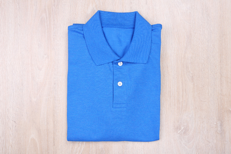 Fold blue polo shirt on wooden backgroundの写真素材