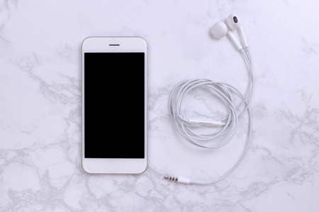 White mockup smartphon with earphone on marble backgroundの写真素材