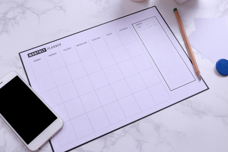 White mockup smartphone and planner schedule on marble backgroundの写真素材