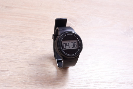 Black digital watches on wooden background