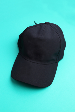Black cap on green pastel backgroundの写真素材