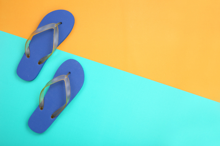Blue rubber slippers on orange and blue pastel  with space for textの写真素材