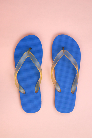 Top view blue rubber slippers on pink pastelの写真素材