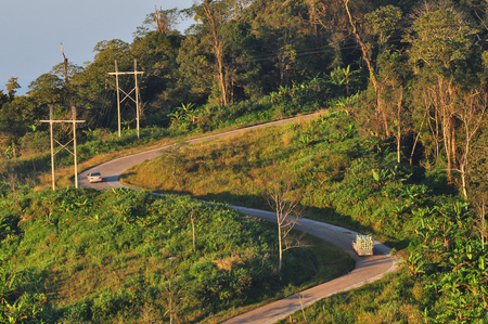 Curve road with car through mountain and forest with sunlightの写真素材