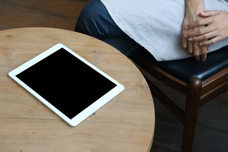 Business woman sit on table with tablet mockup on wooden deskの写真素材