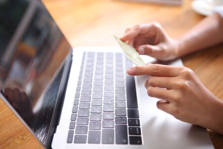 Close up woman holding credit cart with laptop