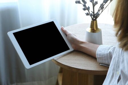 Business woman using tablet  with holding on wooden desk