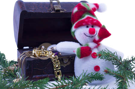Snowman and a treassure chest full with jewelry isolate on white backgroundの写真素材